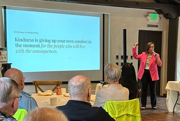 Dr. Isa Karabed presenting Kindness in Leadership beside her slide